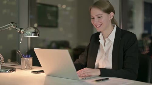 Woman Smiling and Waving During Video Conference