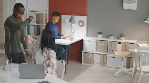 Office Workers in Masks Greet and Work at Desks