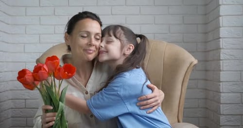 Child Giving Mother Flowers and a Hug