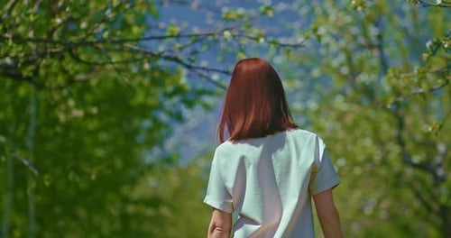 Young Woman is Walking Alone in Beautiful Blooming Garden in Early Spring Rear View Prores