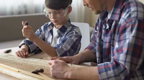 Cute Attentive Boy Working With Screwdriver and Wood, Father Teaching Son