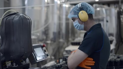 Factory Worker Operating Conveyor With Beer Cans Moving Medium Shot