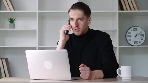 Angry Male Businessman Talking on the Phone Scolding Employees Remotely Sitting in the Office at the