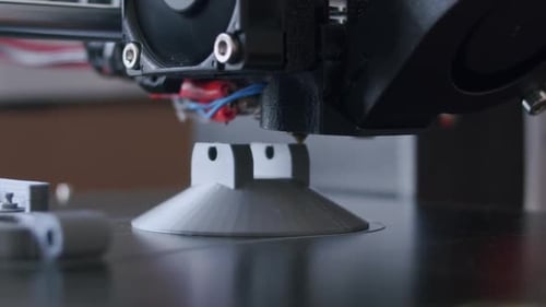 Close Up of an 3d printing process. The 3d printer prints with an grey filament. The object is almos