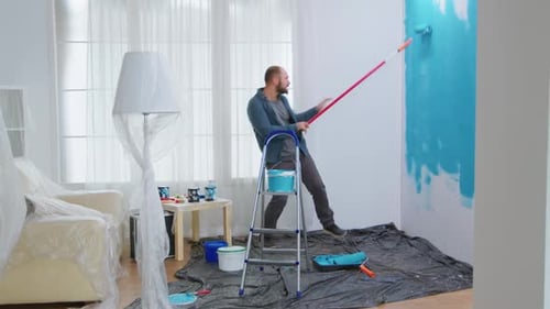 Handyman Dancing and Painting Wall