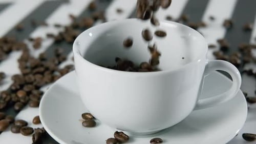 Coffee Beans Falling Into a White Coffee Cup