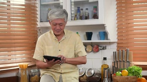 Senior Using Tablet in Warm Kitchen