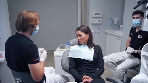 Dentist and patient in dental office. Young woman is sitting in the dental chair