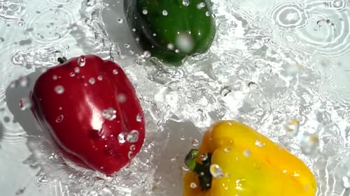 Vibrant Peppers Plunging into Refreshing Water