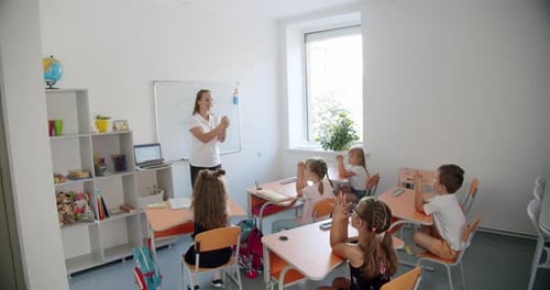 Teacher Explaining Lesson to Elementary School Students