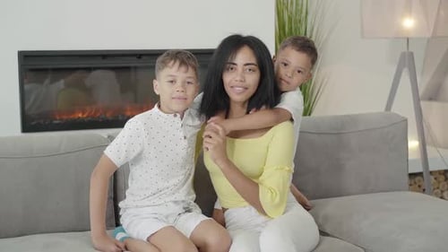 Cheerful Mother Sitting on Couch with Her Sons
