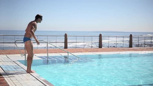 Young man diving into swimming pool