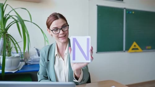Woman Teaching Letters with Flashcards in Classroom