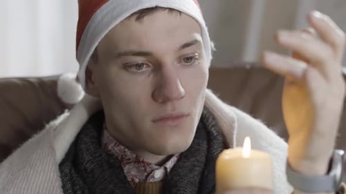 Young Adult Blows Out Christmas Candle