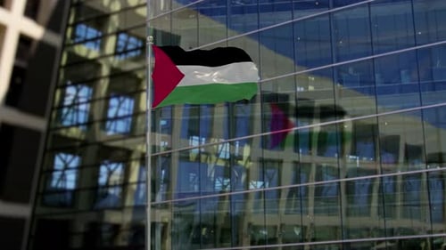 Waving Palestinian Flag in Front of Modern Office Building