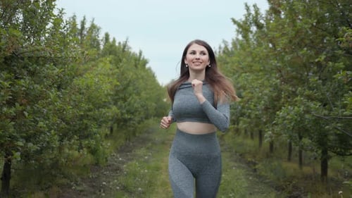Young Woman Runner Training in Summer Park