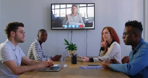 Creative business colleagues in video conference in meeting room in modern office