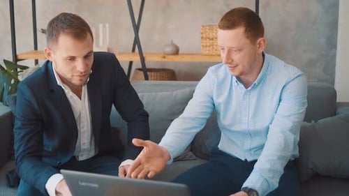 Young Men Discussing Business on a Laptop