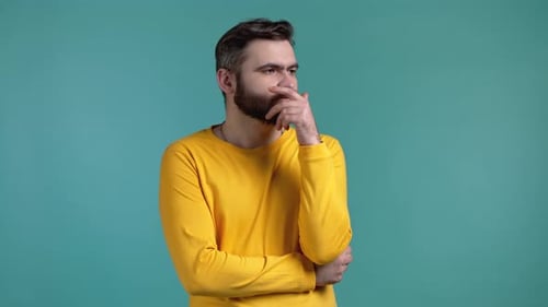 Man Thinking and Looking Away on Teal Background