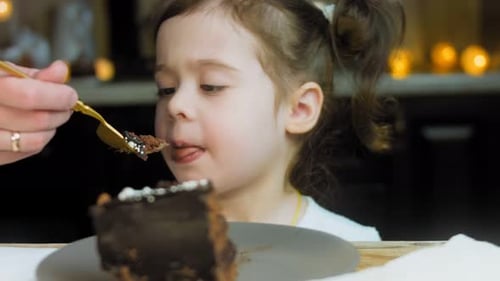 Child Eats Chocolate Cake with Golden Fork