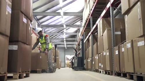 Warehouse Worker Carrying Cardboard Boxes