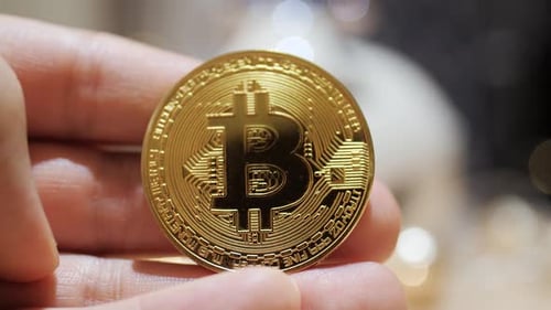 Holding Bitcoin Crypto Currency Coin Close Up