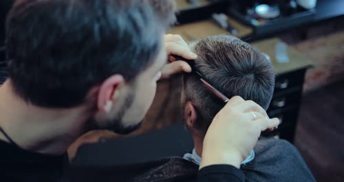 Bearded Barber Giving Haircut in Barbershop