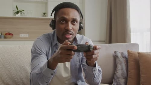 Man Playing Video Games at Home on Couch