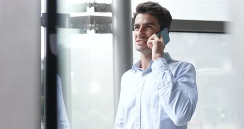 Handsome Man Talking on Mobile Phone in Modern Office