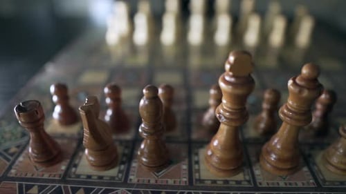 Nahaufnahme von hölzernen Schachfiguren, die tagsüber für ein Schachspiel auf einem Retro-Schachbrett bereit sind. Unschärfe