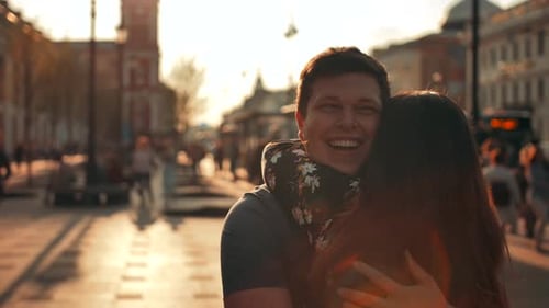 A Guy Meets a Girl Walking Down the Street and Gives Her a Hug, Close Up