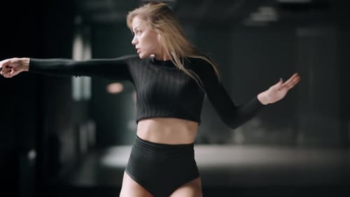 Hot Girl Is Dancing at the Dark Studio Background. Sexy Blonde Woman Is Practicing Dance