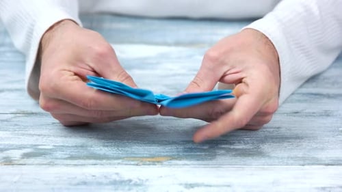 Close Up Male Hands Folding Origami Figure.