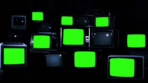 Nine Televisions turning on Green Chroma Screens in a Pile of Retro TVs. Dark Tone.