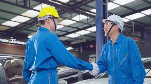 Asian two automotive mechanic men check and maintenance to repair engine machine in garage.