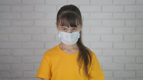 Child Wearing Mask Holds Sign