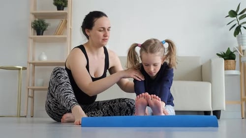Mother and Daughter Stretching Together on Yoga Mat