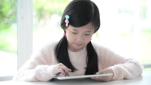 Beautiful Asian Girl Using Tablet On White Table