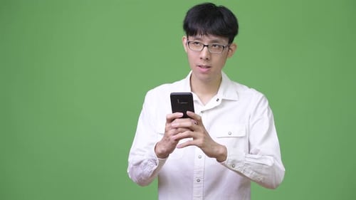 Young Adult Using Smartphone on Green Screen