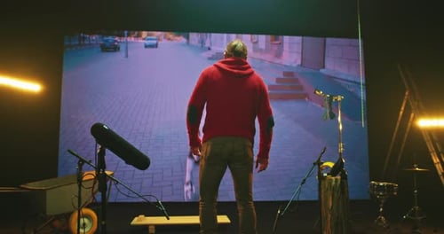 Man Stands Before Animation on Large Screen