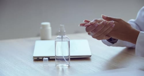 Professional Sanitizing Hands and Laptop in Office