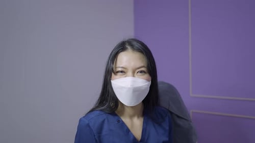 Thai Doctor Wearing Eye Lenses Smiles and Looks at the Camera in Close Up