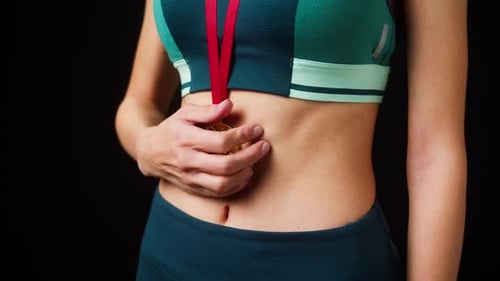 Toned Woman Holding Gold Medal
