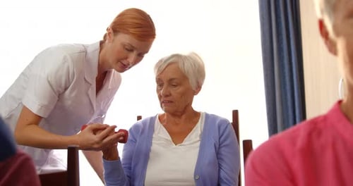 Seniors Lift Dumbbells in Bright Rehabilitation Center