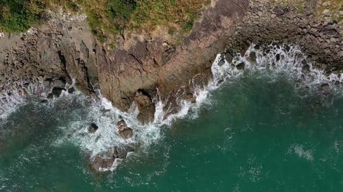 Aerial View of Waves Crashing on Rocky Coastline