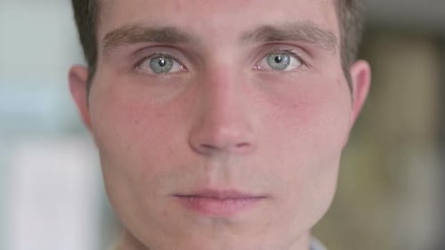 Close Up of Serious Young Man Looking at Camera