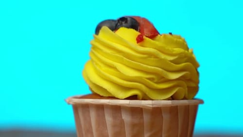 Delicious Cupcake with Yellow Icing and Berries