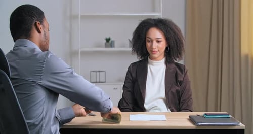 Unrecognizable Afro American Business Man Sitting at Office Table Gives Money Salary Dollars to