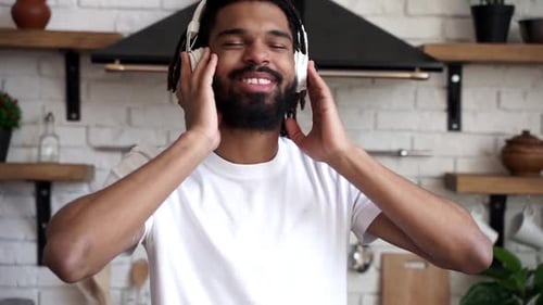 Man Enjoys Music on Headphones in Kitchen