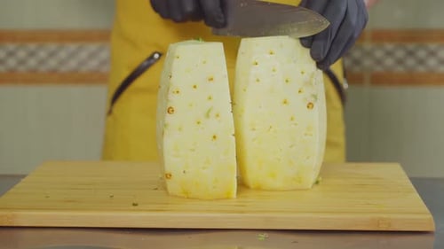 Professional Male Cook Is Slicing Pineapple on Pieces, Close-up